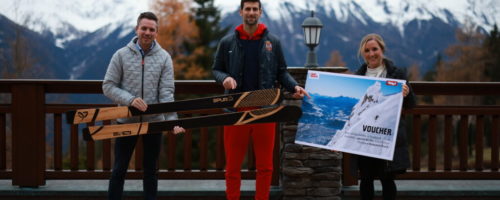 Florian Phleps (Geschäftsführer Tirol Werbung) und Julia Zraunig (Eventmanagerin bei Innsbruck Tourismus) bei der Übergabe des Urlaubsgutscheins sowie der SPURart Ski an Novak Djokovic. © KosmosTennis